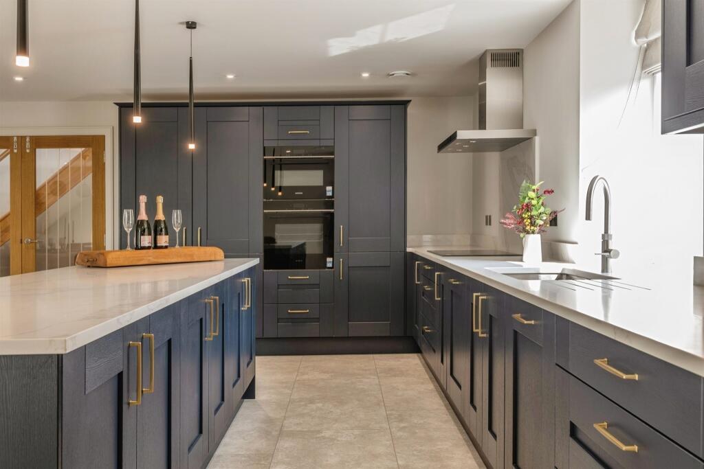 Plot 2 kitchen with a central island and integrated appliances